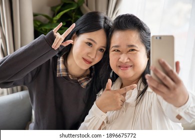 Lovely Asian Senior Mother And Young Daughter Taking Smartphone Photo Selfie With Happy Family Life, Single Mom, Togetherness Concept