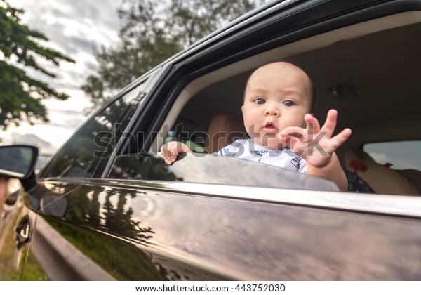 lovely baby\
in car with funny OK signal by\
fingers