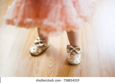 lovely beautiful baby girl infant newborn child kids leg foot pink lace ribbon skirt gold sandals fashion modern cool  hearts shoe  - Shutterstock ID 758814319