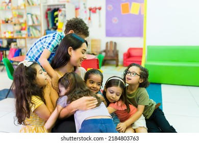 Lovely beautiful preschool teacher hugging her kindergarten students and enjoying coming back to school  - Shutterstock ID 2184803763