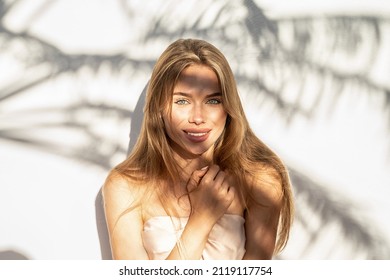 Lovely beautiful young blonde woman with natural freckles smiling to the camera. Natural shadows. A lot of copy space.