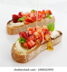 A Lovely Breakfast Bruschetta. Two Slices Of Toasted Sour Dough Spread With Cream Cheese And Topped With Fresh Strawberries And Basil. All Bought Together With A Drizzle Of Honey. Simple But Stylish.