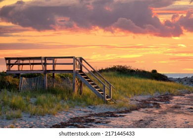 Lovely Cape Cod beach scene with colorful sunlit clouds and sun about to drop below the horizon. Vibrant summer sunset captured at Corporation Beach in Dennis, Massachusetts. - Powered by Shutterstock