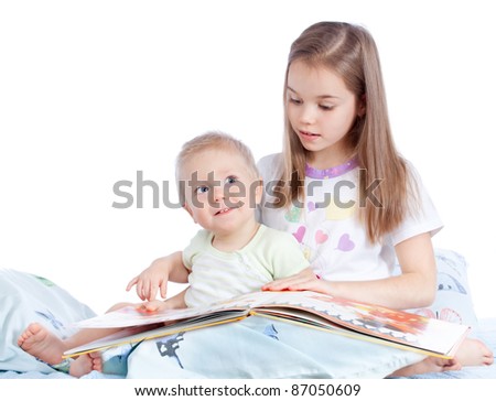 Similar – Mother reading book to her sons in the bed