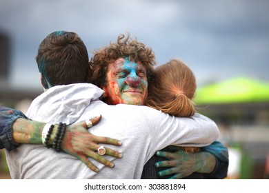 Lovely Colorfully Painted Clown Hugging Strangers Outdoors