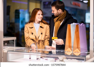 lovely couple choose and buy luxurious jewelry in shopping center inside of mall center - Powered by Shutterstock