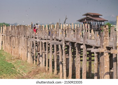A lovely couple crossing the Bein Bridge, Myanmar with flying birds in the sky - Shutterstock ID 2150923335