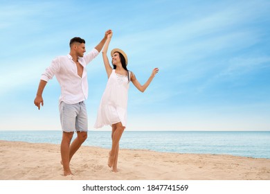 Lovely couple dancing on beach near sea. Space for text - Powered by Shutterstock