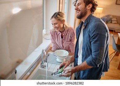 Lovely couple doing the dishes together in the kitchen - Powered by Shutterstock