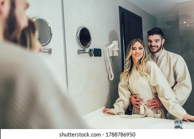 Lovely Couple In Front Of The Mirror While Getting Ready In The Bathroom