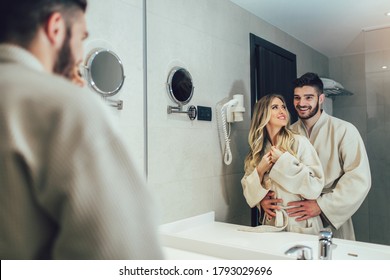 Lovely Couple In Front Of The Mirror While Getting Ready In The Bathroom