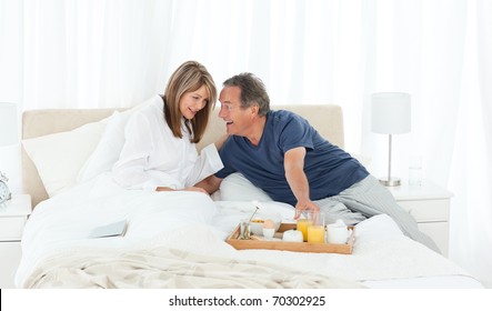 Lovely couple  having breakfast in their bed at home - Powered by Shutterstock