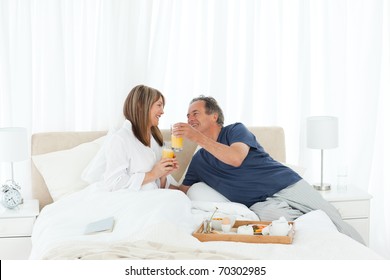 Lovely couple  having breakfast in their bed at home - Powered by Shutterstock