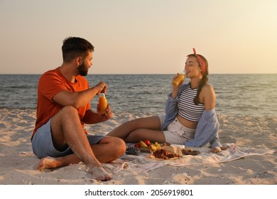 Lovely couple having picnic on sandy beach near sea - Powered by Shutterstock