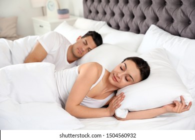 Lovely Couple Sleeping In Large Comfortable Bed