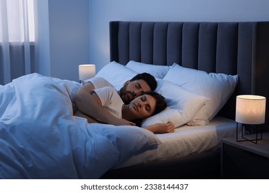 Lovely couple sleeping together in bed at night - Powered by Shutterstock