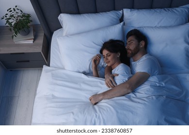 Lovely couple sleeping together in bed at night, top view - Powered by Shutterstock