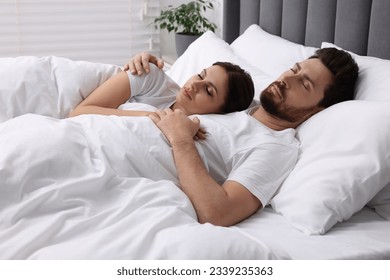 Lovely couple sleeping together in bed at home - Powered by Shutterstock