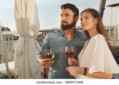 Lovely Couple Smiling, Looking Away Joyfully While Drinking Wine On Bar Terrace