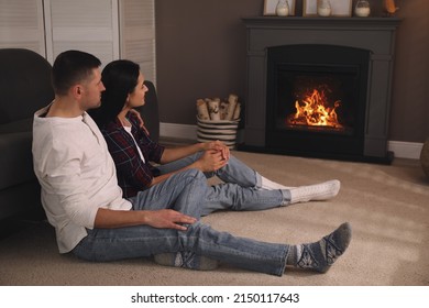 Lovely couple spending time together near fireplace at home - Powered by Shutterstock