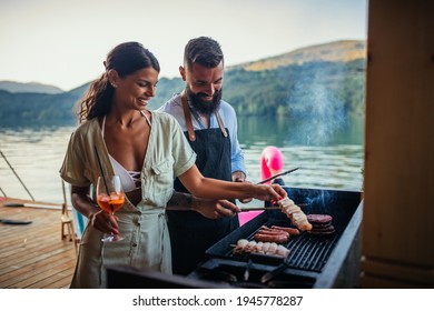 Lovely couple spending together day off, barbecuing and drinking some cocktails