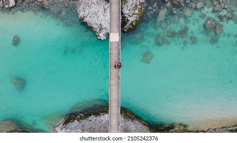 Lovely couple standing together on bridge over crystal blue Soca river, Slovenia