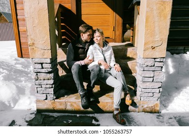 Lovely couple together sitting at the front steps of their home on a sunny day. Pretty woman and attractive man wearing stylish casual clothes smiling and hugging. - Powered by Shutterstock