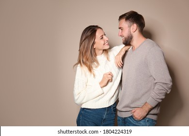 Lovely couple in warm sweaters on beige background - Powered by Shutterstock