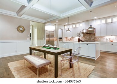 Lovely Craftsman Style Dining Space With Coffered Cealing Over Rustic Wooden Dining Table Surrounded By Modern Glass Chairs And Light Pink Tufted Bench. Northwest, USA
