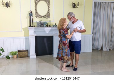 Lovely Elderly Couple Enjoys Romantic Dance To Celebrate Anniversary At Home. Senior Couple Doing Exercise By Dancing For Health. Elderly Wife And Husband Share Happy Time Together With Dance. 