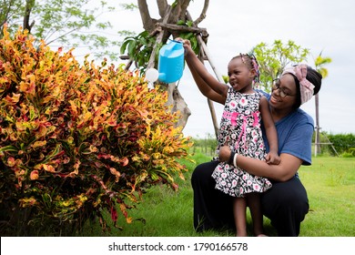 Lovely Family Couples Participate In Holiday Activities By Watering Plants And Keeping Plants In The Front Garden. They Live Happily After Working Hard. Concept On Gardening And Maintenance