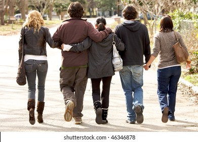 A Lovely  Family Holding Eachother Walking Away From Camera