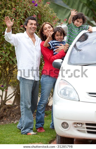 Lovely family\
waving and smiling from the\
car
