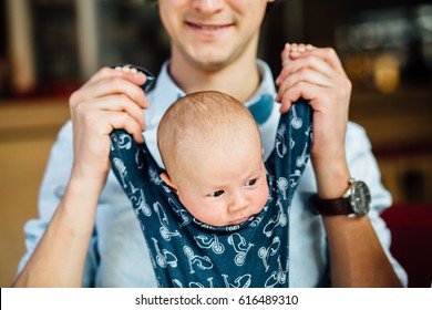 Lovely Father Playing With His Little Two Month Old Son. Dad Holding Newborn Baby Boy By The Hands. Close Up.