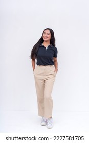 A lovely Filipina intern in a black polo shirt and khaki pants. Isolated on a white background, full body photo. - Shutterstock ID 2227581705