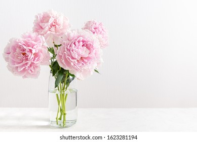 Lovely flowers in glass vase. Beautiful bouquet of pink peonies. Floral composition, copy space for text. Wallpaper, greeting card, poster, floral shop concept