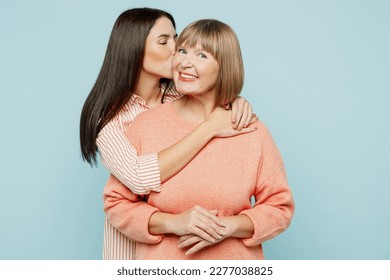 Lovely fun smiling happy caucasian elder parent mom with young adult daughter two women together wearing casual clothes hugging cuddle kiss isolated on plain blue cyan background. Family day concept - Shutterstock ID 2277038825