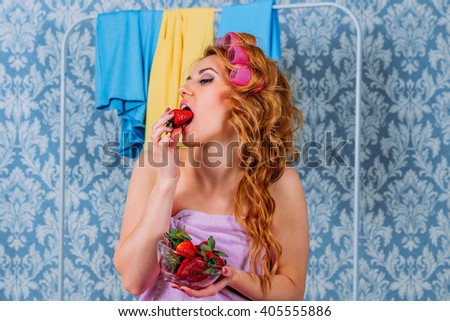 Lovely girl in the style Pin-up eating a strawberry