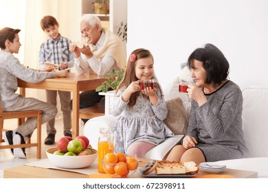 Lovely grandmother and beautiful granddaughter drinking delicious, warm tea  - Powered by Shutterstock