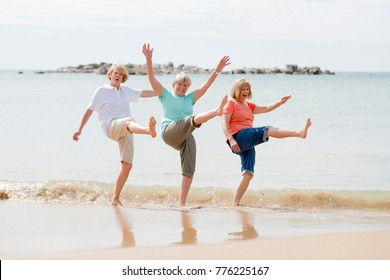 Wunderschöne Gruppe von drei älteren Frauen im Ruhestand auf ihren 60ern, die Spaß haben, zusammen glücklich spazieren gehen am Strand lächelnd verspielt in der Freundschaft und Freundinnen im Urlaub Konzept