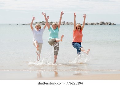 Lovely Group Of Three Senior Mature Retired Women On Their 60s Having Fun Enjoying Together Happy Walking On The Beach Smiling Playful In Female Friendship And Girlfriends On Holidays Concept