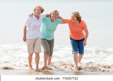 Lovely Group Of Three Senior Mature Retired Women On Their 60s Having Fun Enjoying Together Happy Walking On The Beach Smiling Playful In Female Friendship And Girlfriends On Holidays Concept