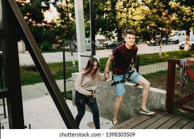 Lovely Happy Caucasian Couple Running On A Zipline Platform While Holding Hands In Their Dating Time.