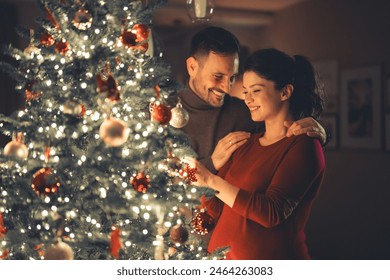 A lovely happy young adult married couple enjoying each others company while decorating the Christmas tree together on cozy Christmas Eve. - Powered by Shutterstock