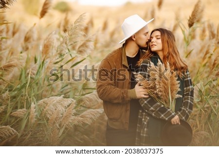 Lovely hipster couple enjoying each other in the autumn park. Nice autumn day. Young couple walking and hugging outdoors, The concept of youth, love and lifestyle.