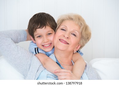Lovely little boy with his grandmother having fun and happy moments together at home