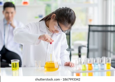 Lovely little girl scientist concentrate to test color chemical in laboratory by using dropper with day light. Concept of good practice and education of science for children support.