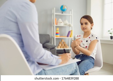 Lovely Little Girl Talking To Child Psychotherapist At Medical Office. Mental Health Problem Treatment