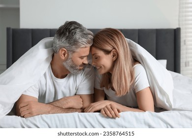 Lovely mature couple in bed at home - Powered by Shutterstock