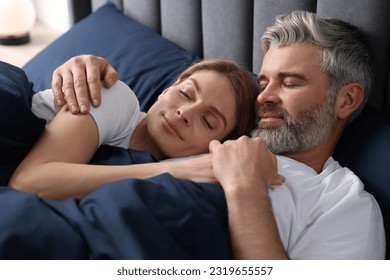 Lovely mature couple sleeping together in bed at home - Powered by Shutterstock